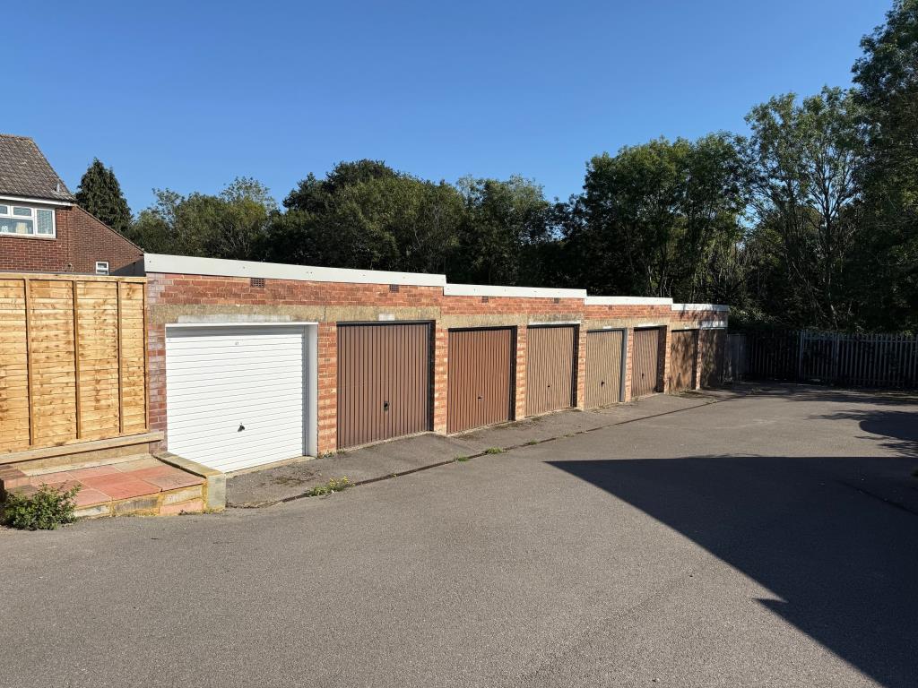 Lot: 27 - GARAGE BLOCK WITH CONSENT FOR CONSTRUCTION OF TWO HOUSES - Block of eight garages looking down the hill